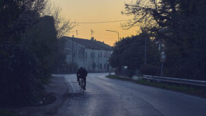 Ciclista al tramonto nella Pianura Padana – fotografia di Stefano Delia Uomo in bicicletta percorre una strada di campagna nella Pianura Padana al tramonto