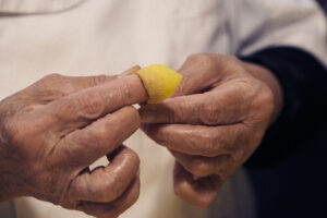 Cappelletti fatti a mano, tradizione emiliana Mani che chiudono un cappelletto di pasta fresca ripiena, cucina emiliana tradizionale