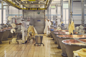 Parmigiano Reggiano – Produzione artigianale in caseificio | Foto Stefano Delìa Caseificio tradizionale per la produzione del Parmigiano Reggiano DOP, con casari al lavoro tra i calderoni di rame, foto di Stefano Delìa