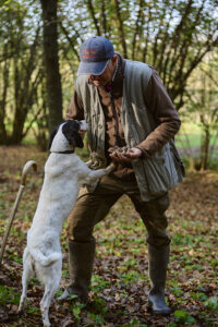 Cerca tartufi con cane – Trifulau piemontese nel bosco | Foto Stefano Delìa Trifulau piemontese con il suo cane da tartufo durante la ricerca nel bosco – fotografia di Stefano Delìa