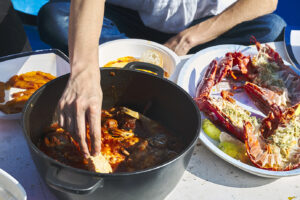 Pranzo di pesce a bordo del peschereccio in Sardegna | Most of Italy | Foto Stefano Delìa Pranzo di pesce a bordo di un peschereccio in Sardegna, piatti con crostacei e zuppa di mare, fotografia di Stefano Delìa per Most of Italy