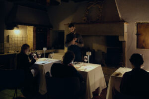 Lo chef Tommaso Tonioni in sala mentre presenta un piatto agli ospiti durante l’evento performativo Se Carne, Questa Carne.