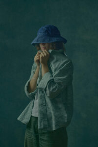 Coca Puma – ritratto moda fotografato da Stefano Delìa Ritratto moda Coca Puma con cappello blu e camicia a quadri, fotografia di Stefano Delìa