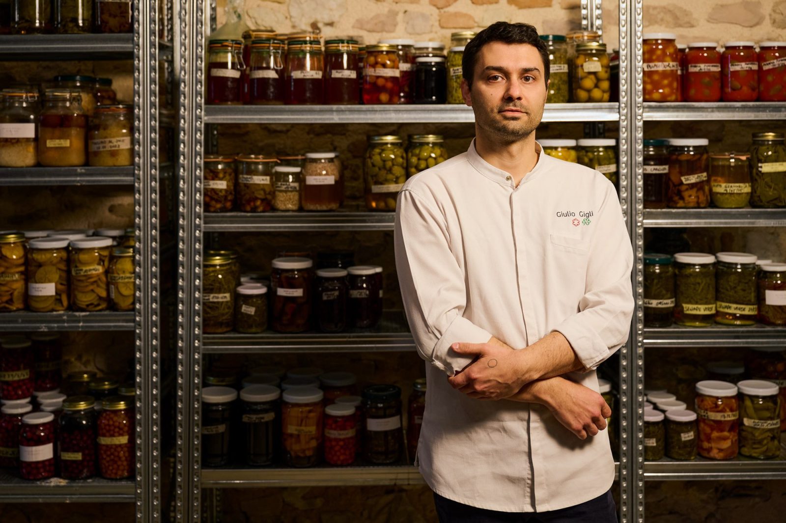 Lo chef Giulio Gigli davanti agli scaffali delle conserve del ristorante UNE